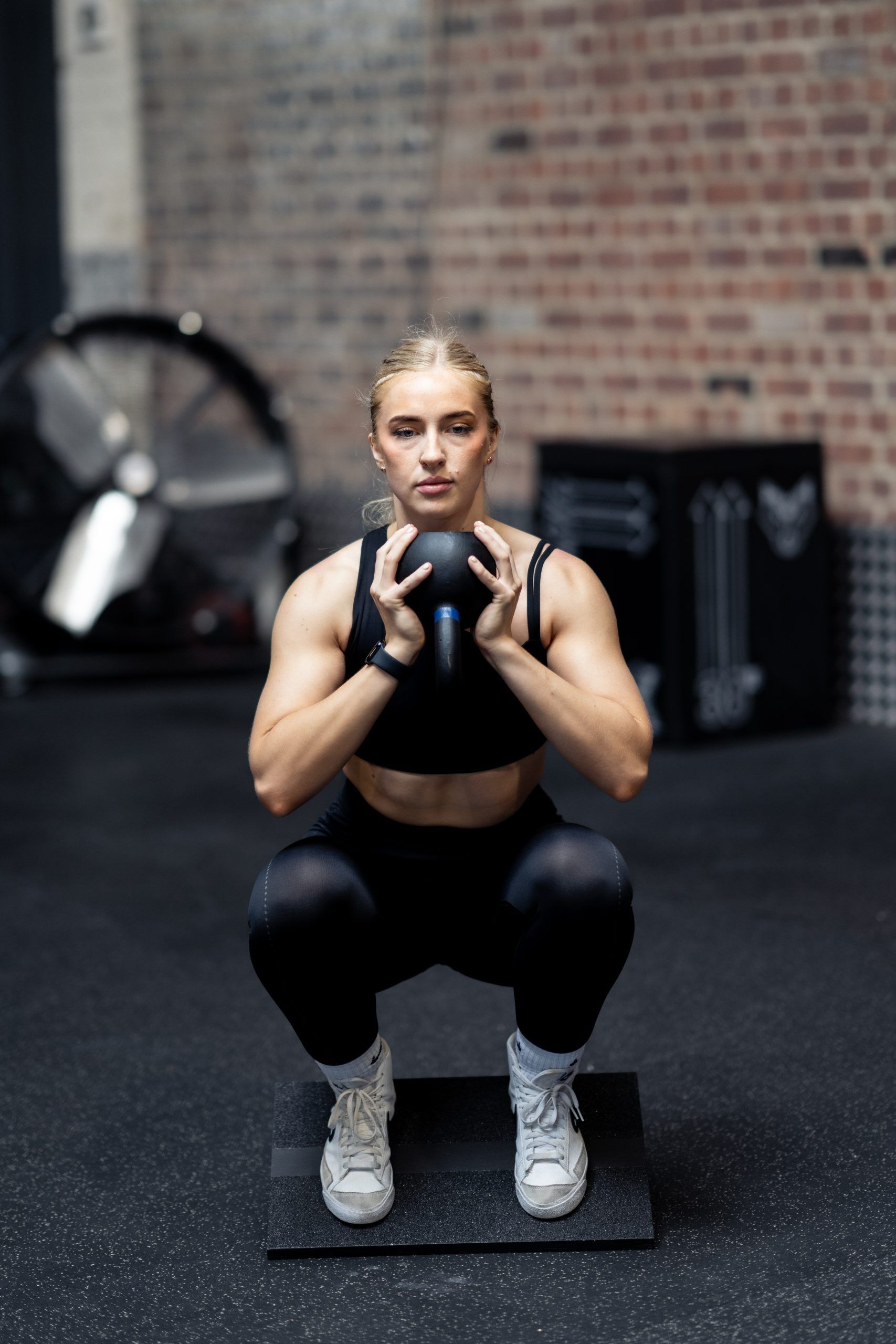 _DSC7569 Woman performing a squat on the black wooden Forte Fitness slant board