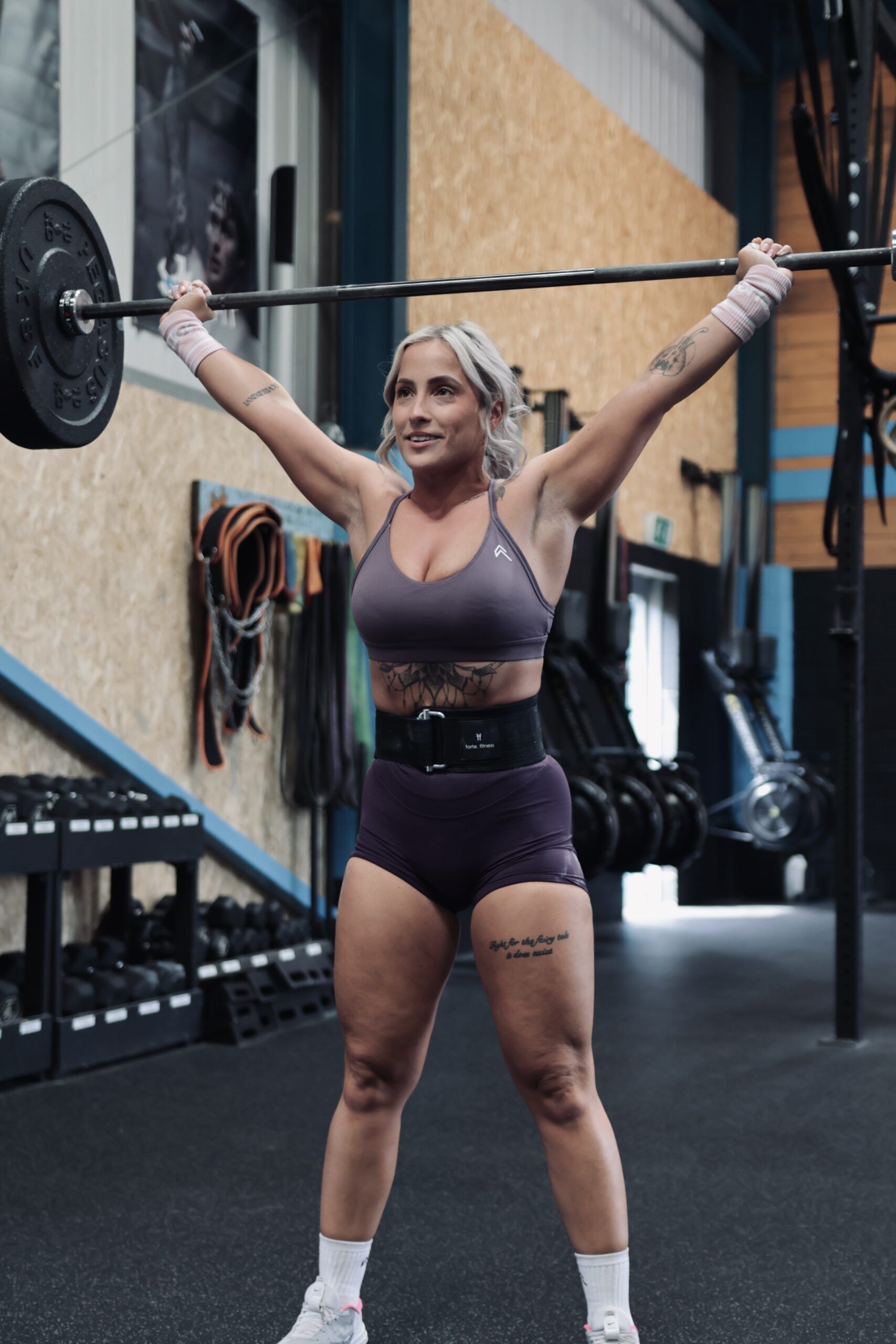 hybrid lifting belt woman performing a snatch weightlifting movement wearing a hybrid lifting belt