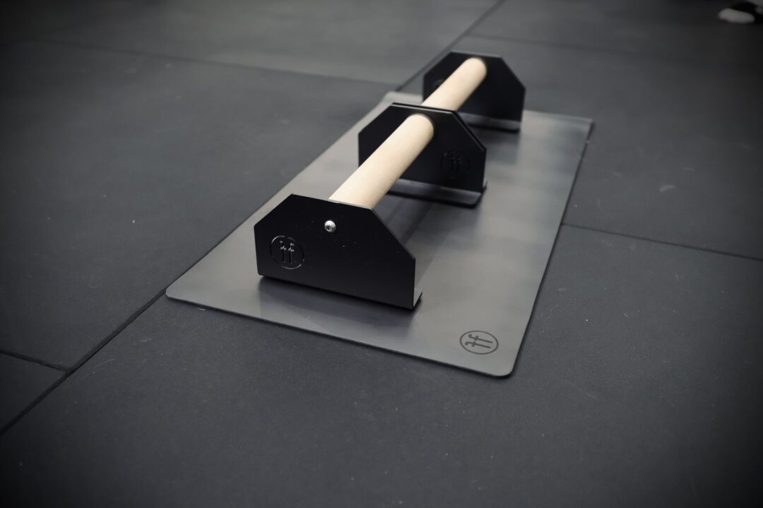 parallettes. small forte fitness parallette bars on a mat