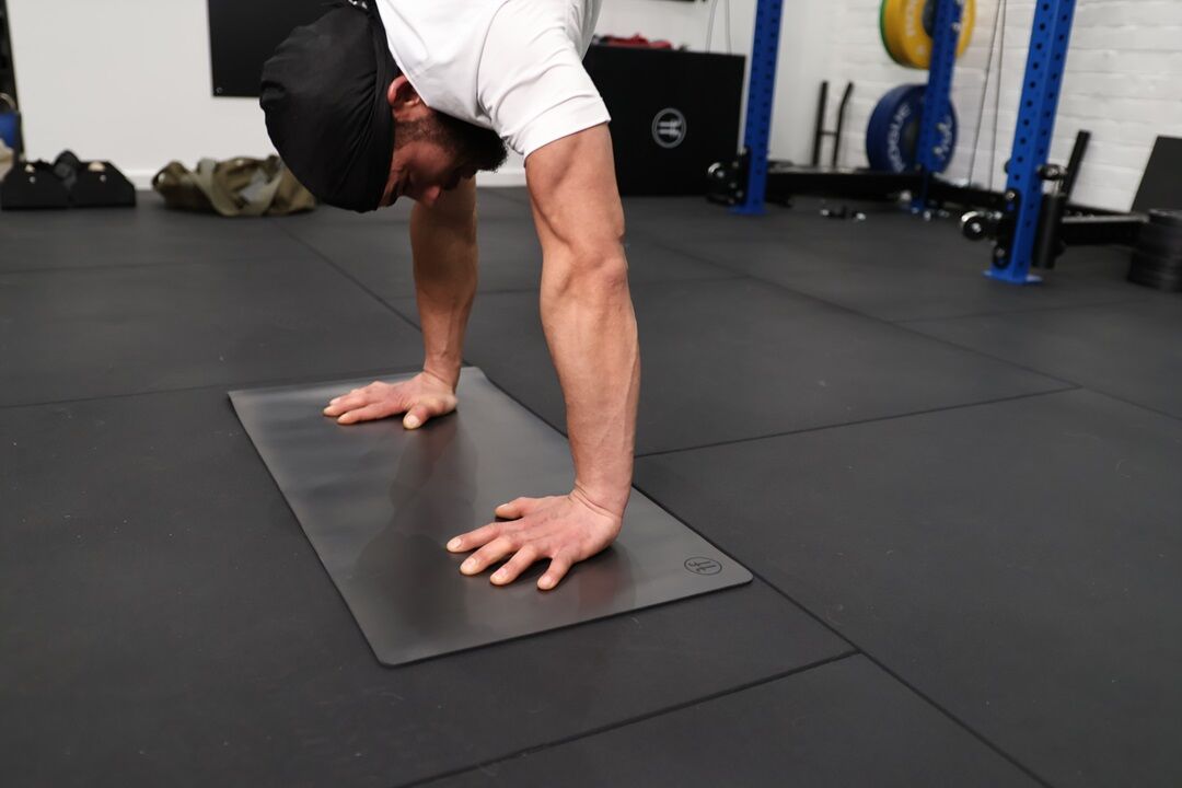 handstand mat man performing a handstand in a gym using a handstand mat