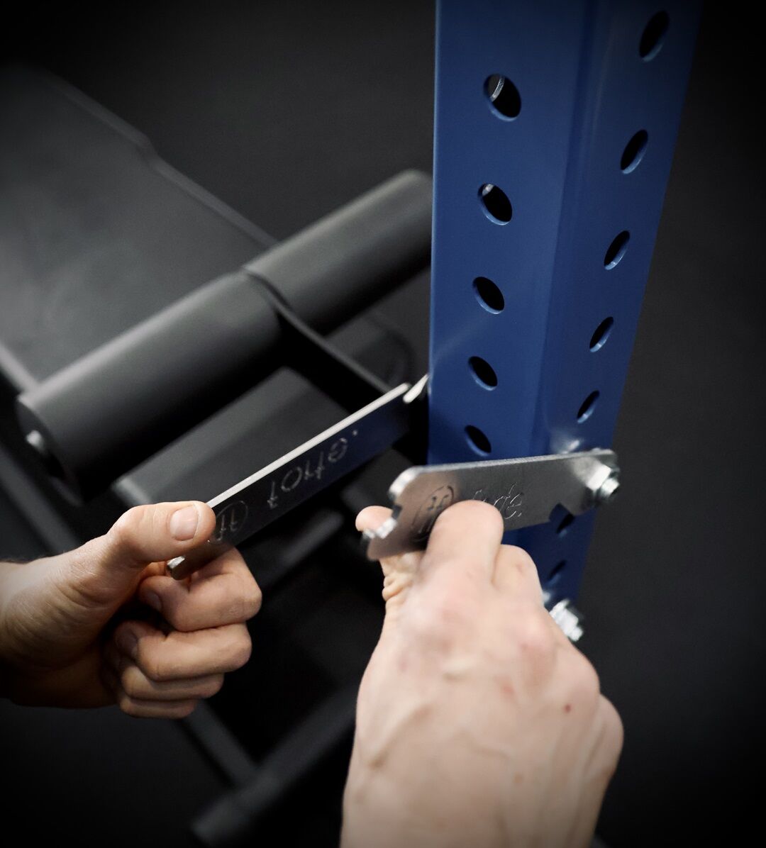 nordic. man mounting a nordic curl attachment to a rig