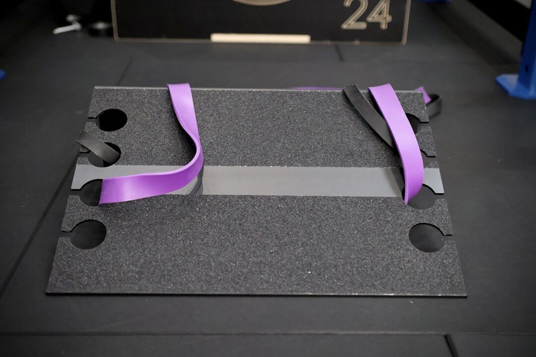 slant resist. slant platform set up in a gym with purple resistance band