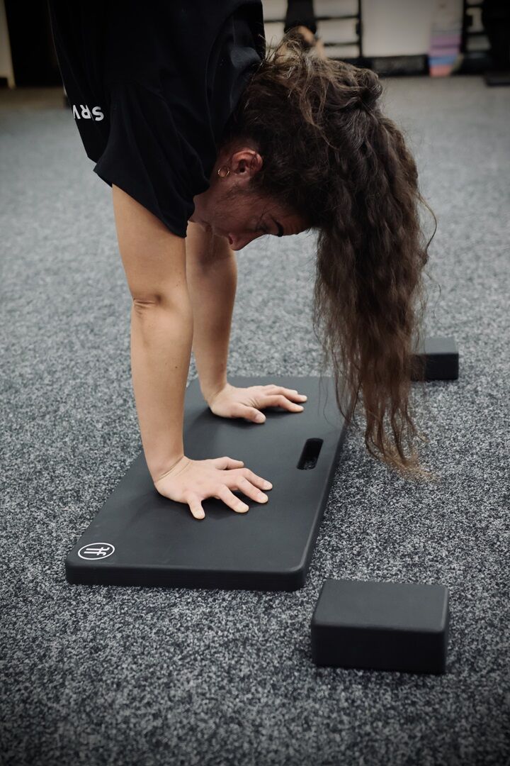 handstand board. woman performing a handstand on a handstand board