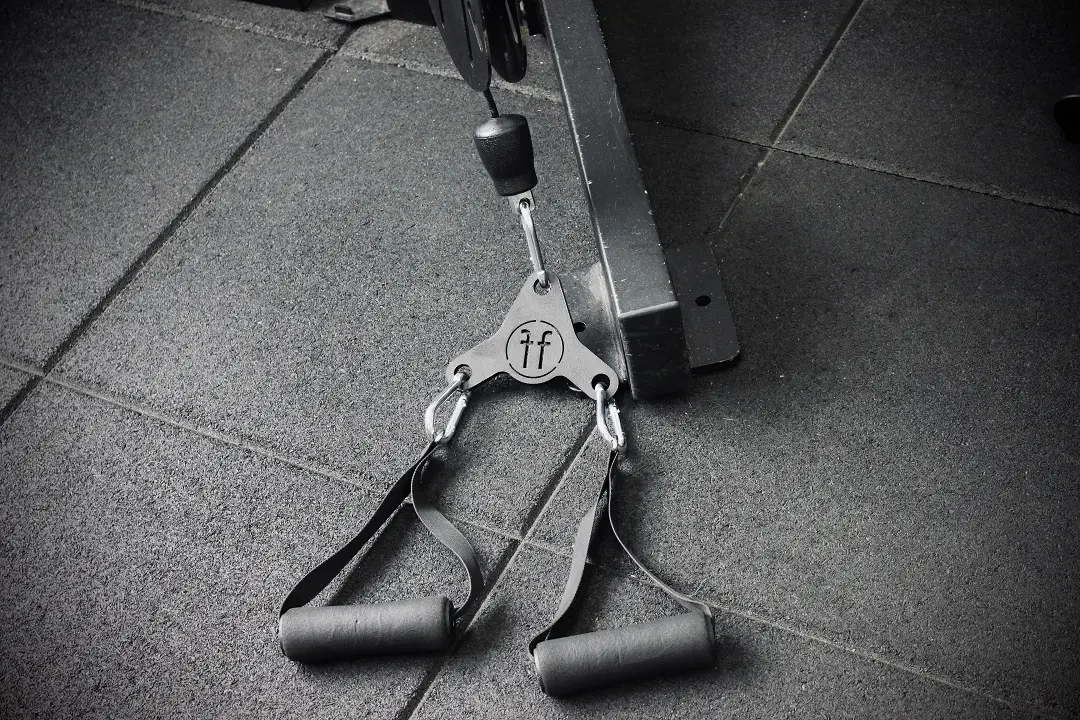 Adapt A Forte Fitness Adapt tool. The tool is attached to a cable machine, and is placed on the floor ready to be used. This picture is in black and white.